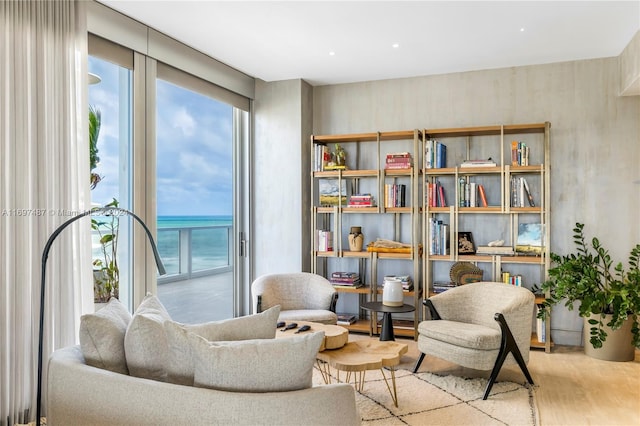 living area with a water view and light hardwood / wood-style floors