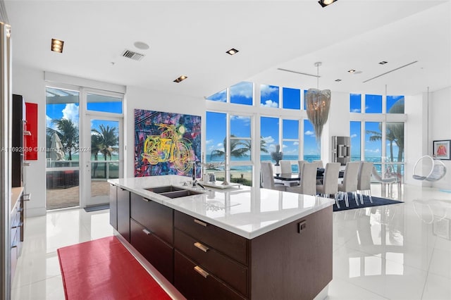 kitchen featuring a center island with sink, floor to ceiling windows, light tile patterned floors, and sink