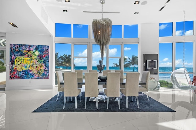 dining area with a water view and light tile patterned floors