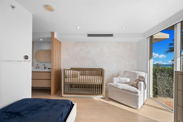 bedroom featuring access to outside, multiple windows, and light hardwood / wood-style floors