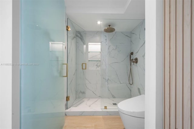 bathroom featuring wood-type flooring, toilet, and a shower with door