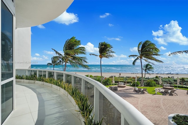 balcony featuring a water view and a beach view