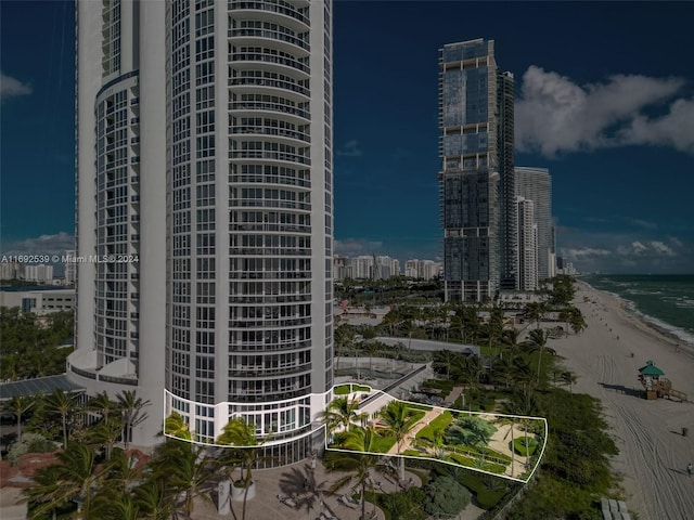 view of building exterior featuring a water view and a beach view