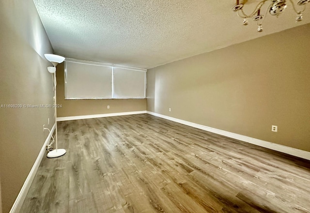 empty room featuring a textured ceiling and light wood-type flooring