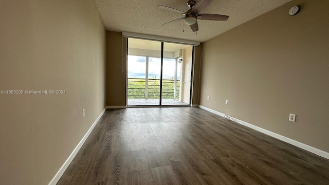 unfurnished room featuring a textured ceiling, dark hardwood / wood-style floors, floor to ceiling windows, and ceiling fan