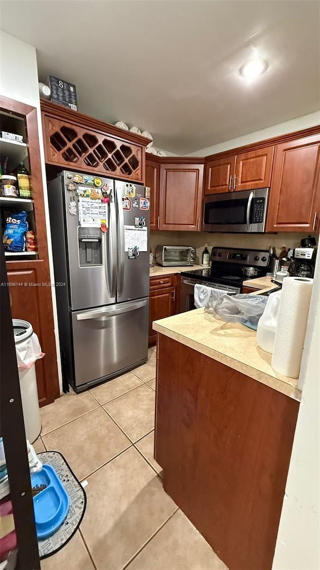 kitchen with light tile patterned flooring and stainless steel appliances