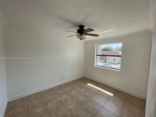 tiled empty room featuring ceiling fan and ornamental molding