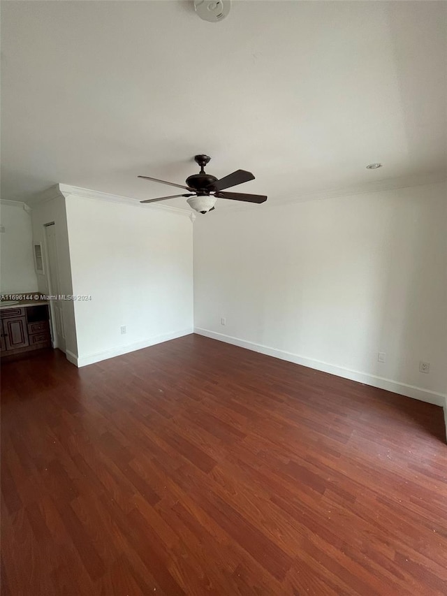 empty room with ceiling fan, dark hardwood / wood-style flooring, and ornamental molding