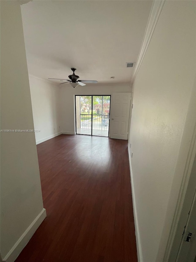 spare room featuring crown molding, ceiling fan, and dark wood-type flooring