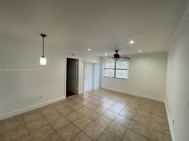 empty room with ceiling fan, light tile patterned flooring, and crown molding