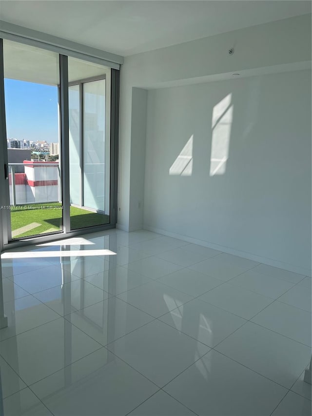 empty room with tile patterned flooring and a water view