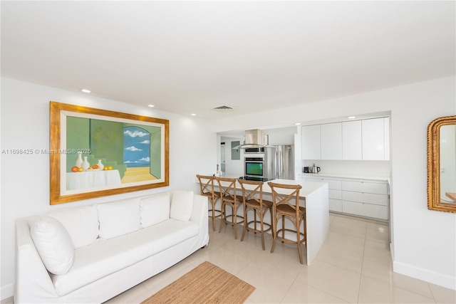 living area with light tile patterned floors, baseboards, recessed lighting, and visible vents