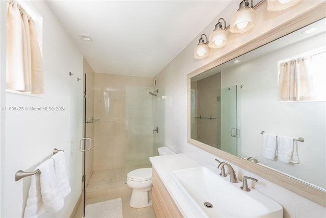 bathroom featuring tile patterned floors, sink, a shower with shower door, and toilet