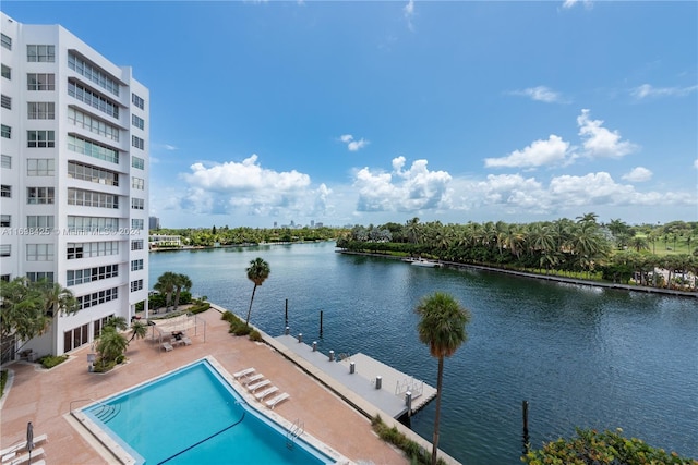 view of swimming pool featuring a patio and a water view