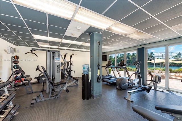 workout area featuring a drop ceiling and a wall mounted air conditioner