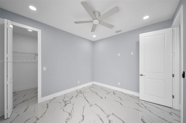 unfurnished bedroom featuring ceiling fan, a closet, and a walk in closet