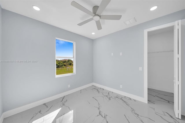 unfurnished bedroom featuring a spacious closet, ceiling fan, and a closet