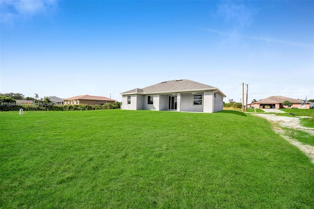 rear view of property featuring a lawn