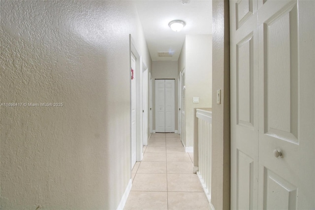 hall featuring light tile patterned floors