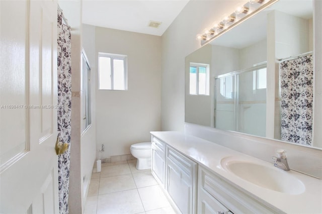 bathroom featuring toilet, a healthy amount of sunlight, walk in shower, and vanity