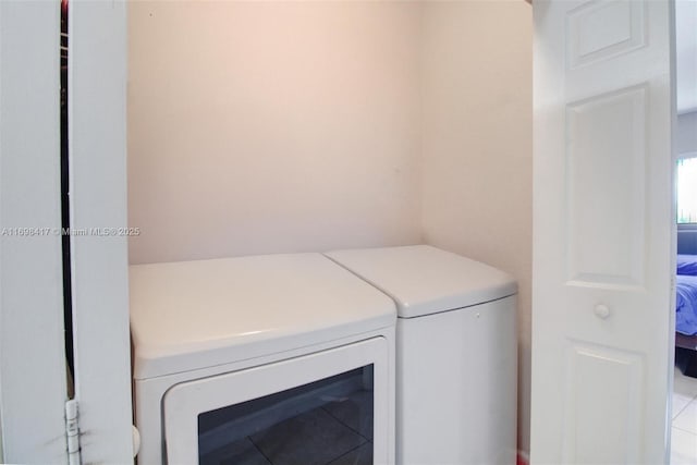 laundry room with light tile patterned floors and separate washer and dryer