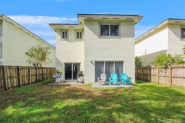 back of house with a lawn and a patio