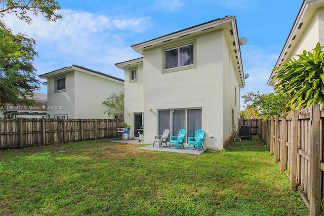 back of property with central AC unit, a yard, and a patio