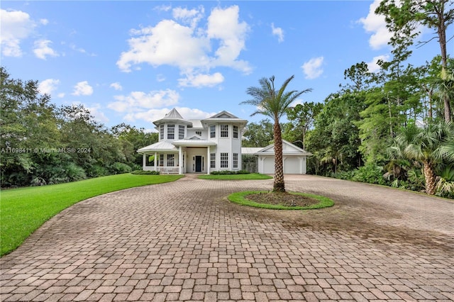 view of front of home featuring a porch, a garage, and a front yard