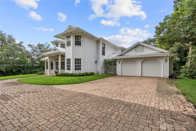 view of front facade featuring a front lawn, a porch, and a garage