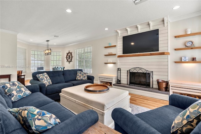 living room with plenty of natural light, light hardwood / wood-style floors, and ornamental molding