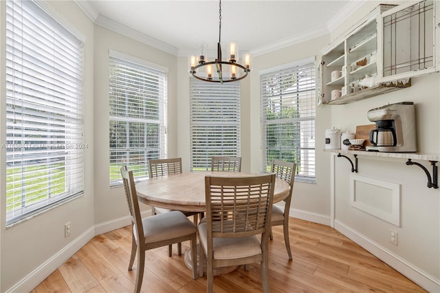 dining room featuring ornamental molding, a healthy amount of sunlight, a notable chandelier, and light wood-type flooring