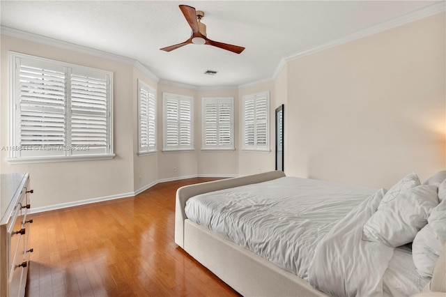 bedroom with hardwood / wood-style flooring, ceiling fan, and crown molding