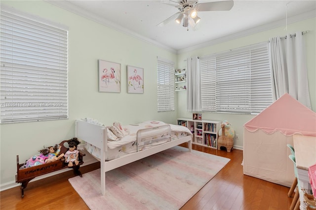 bedroom featuring ceiling fan, crown molding, and wood-type flooring