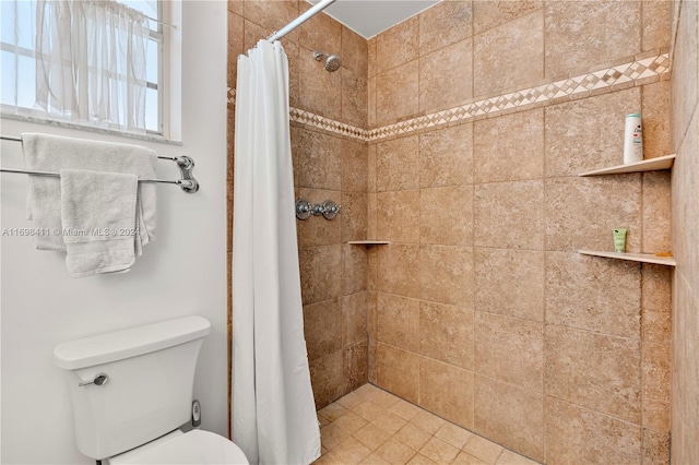 bathroom featuring tile patterned floors, toilet, and walk in shower