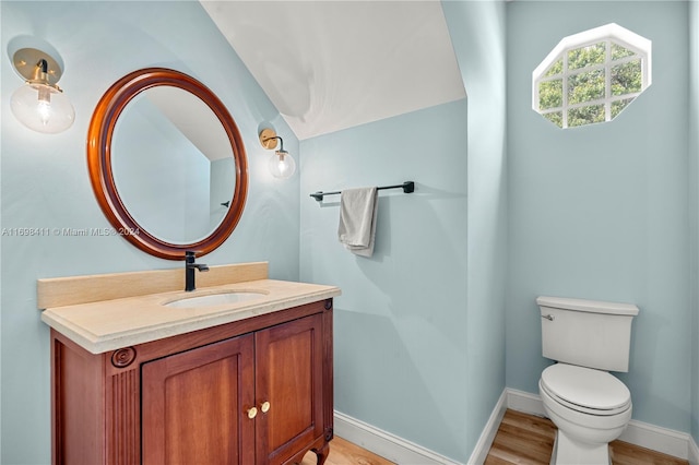 bathroom featuring wood-type flooring, vanity, and toilet