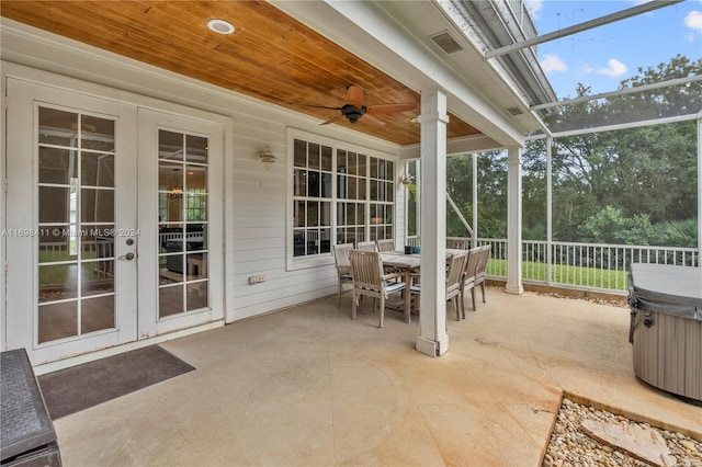 view of patio / terrace featuring ceiling fan, a hot tub, glass enclosure, and french doors