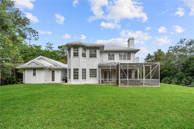 rear view of property with a lanai and a yard