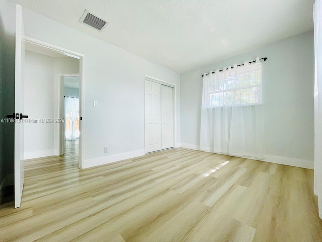 unfurnished bedroom featuring a closet and light hardwood / wood-style flooring