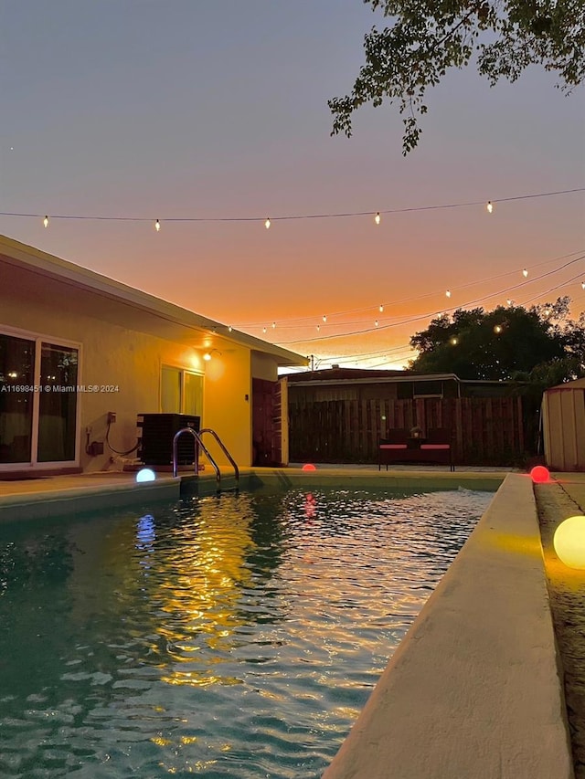 pool at dusk featuring a patio area