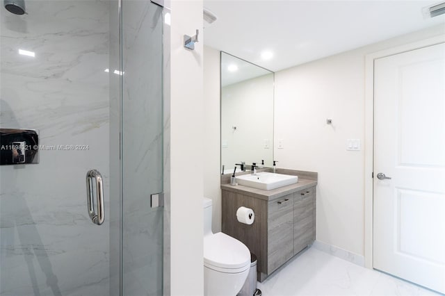 bathroom featuring vanity, an enclosed shower, and toilet