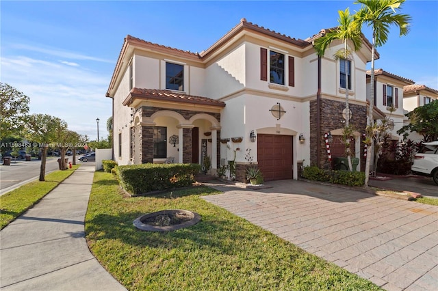 mediterranean / spanish house featuring a front lawn and a garage