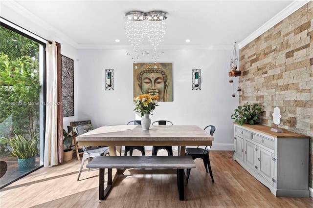 dining room featuring light hardwood / wood-style flooring, a notable chandelier, and ornamental molding