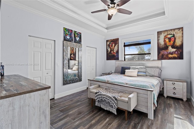 bedroom with a tray ceiling, ceiling fan, dark hardwood / wood-style flooring, and ornamental molding