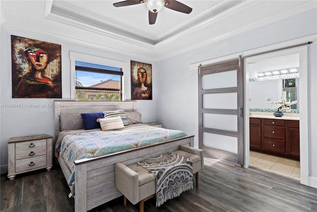 bedroom with ensuite bathroom, a raised ceiling, crown molding, hardwood / wood-style flooring, and ceiling fan