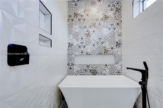 bathroom with a bathtub and tile walls