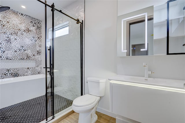 bathroom with hardwood / wood-style flooring, vanity, toilet, and an enclosed shower