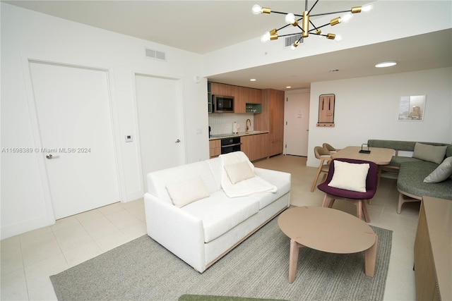 living room with sink, light tile patterned floors, and a notable chandelier