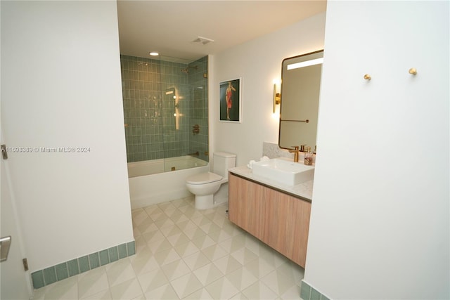 full bathroom featuring toilet, vanity, tile patterned floors, and tiled shower / bath