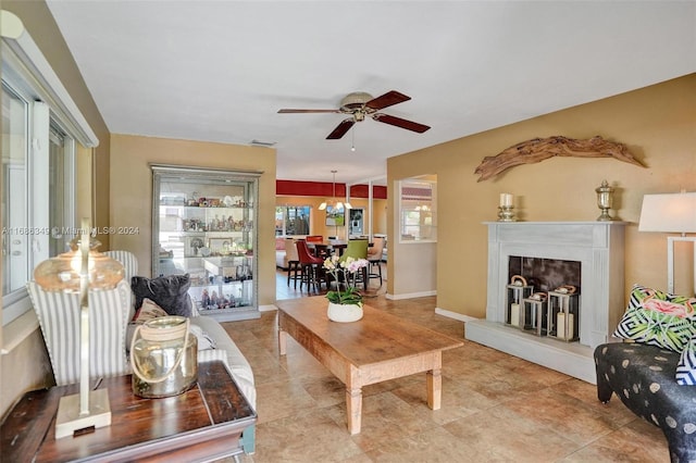 living room with light tile patterned floors and ceiling fan with notable chandelier