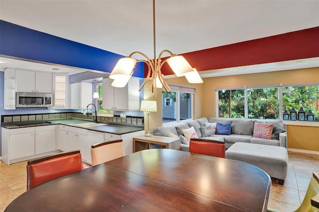 dining space featuring sink and light tile patterned floors